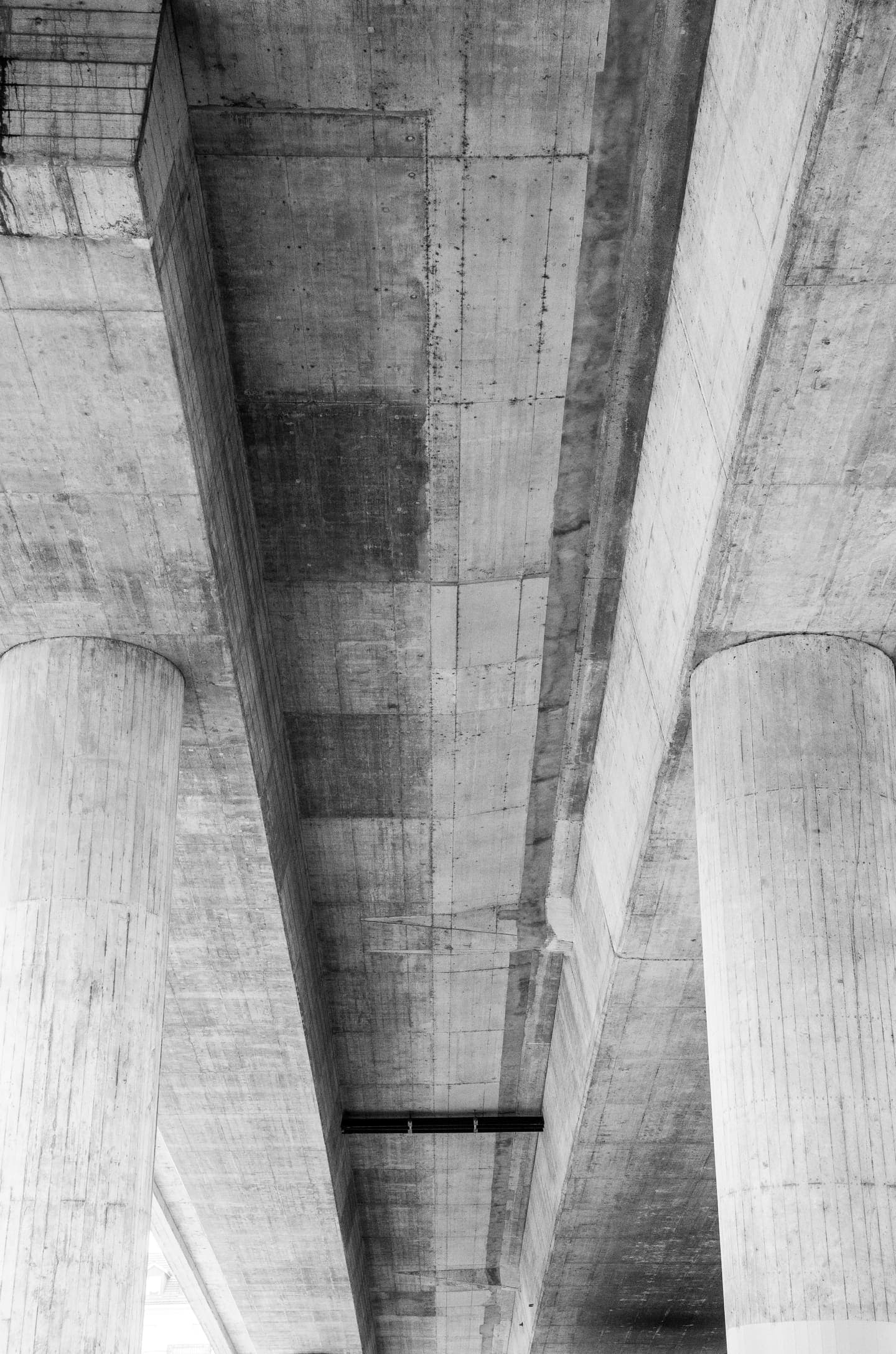 Betonkonstruktion einer Brücke in Schwarzweiss, von unten fotografiert